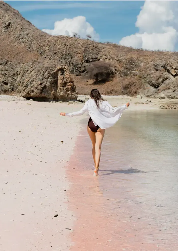 Pasir merah muda Pink Beach berbatasan dengan air jernih