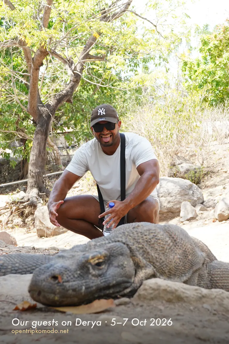 Tamu trip Derya berfoto dengan komodo yang berbaring di Pulau Komodo