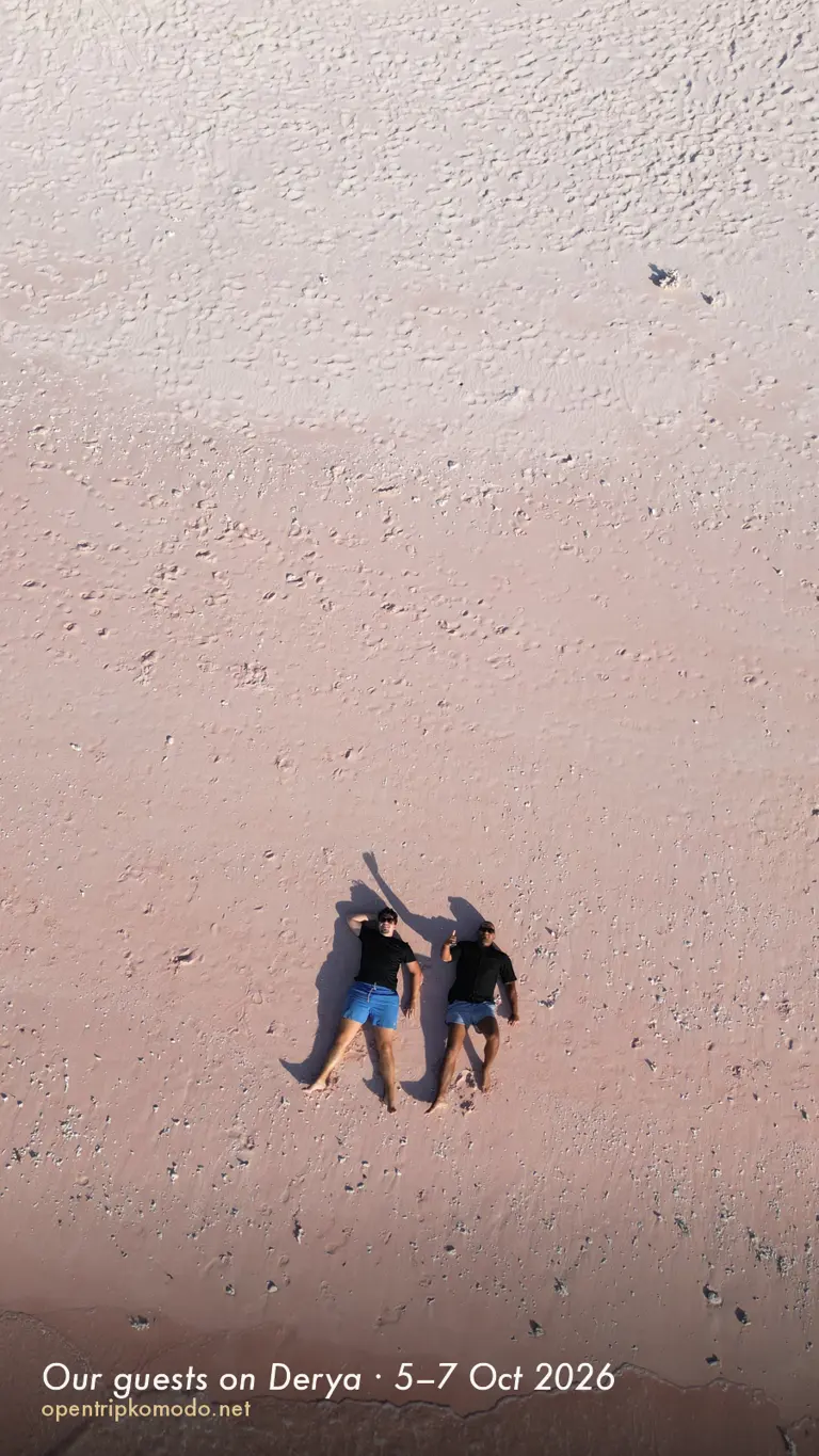 Dua tamu trip Derya berbaring di pasir merah muda Pink Beach, foto drone
