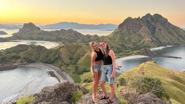 Dua tamu berpelukan di Padar saat matahari terbenam