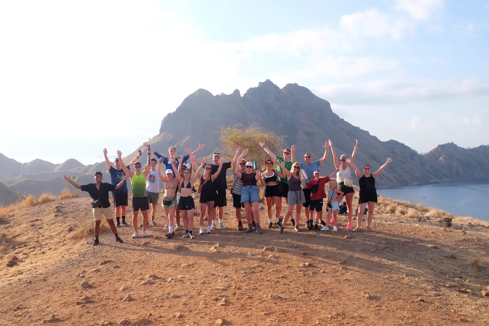Rombongan peserta open trip bersorak di puncak bukit Pulau Padar
