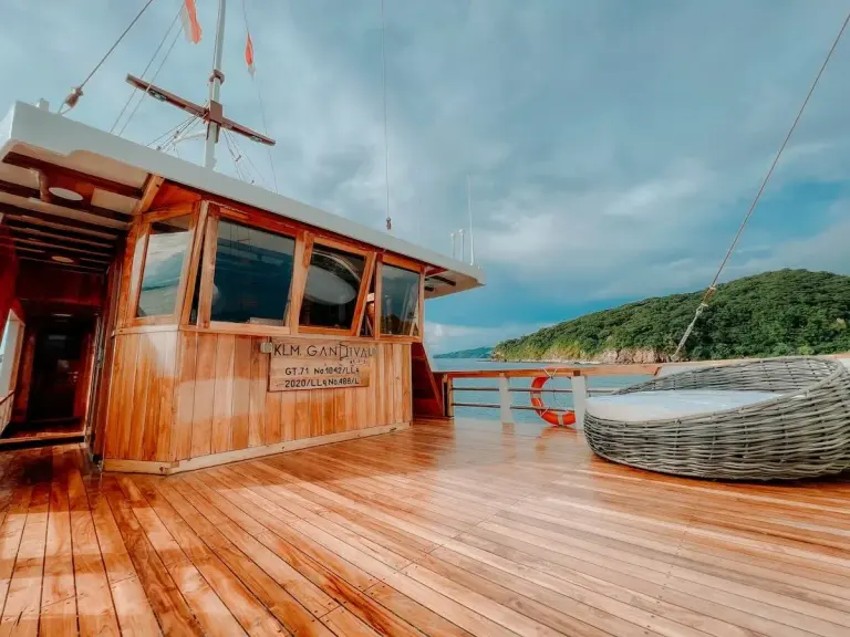 Sundeck kayu Gandiva dengan kasur bundar dan ruang kemudi di belakangnya