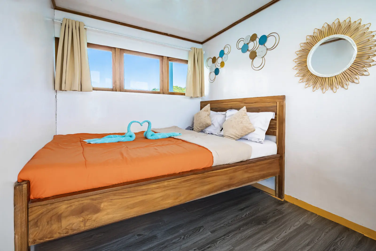Arham Jaya II Private Cabin I, a double bed with a rattan mirror on the wall