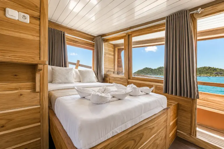 Arora Deluxe Cabin 1, a double bed with white linen