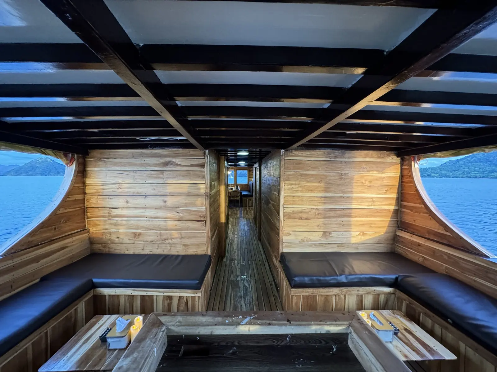 Lounge dalam Bajo Sunset Voyages dengan sofa panjang dan jendela di dua sisi