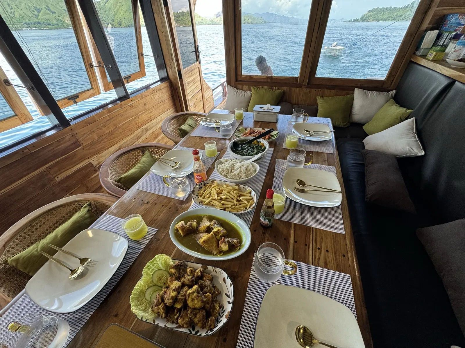 Ruang makan Bajo Sunset Voyages dengan deretan jendela menghadap laut