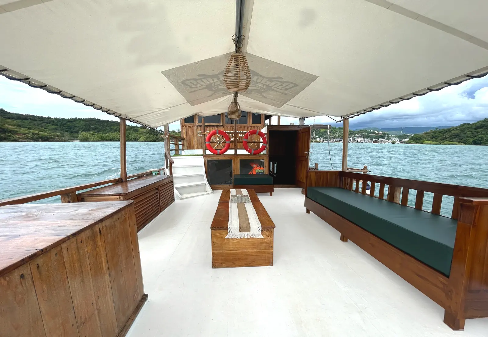 The upper deck of Capt Octopus under a canvas roof, with sofas and wooden tables
