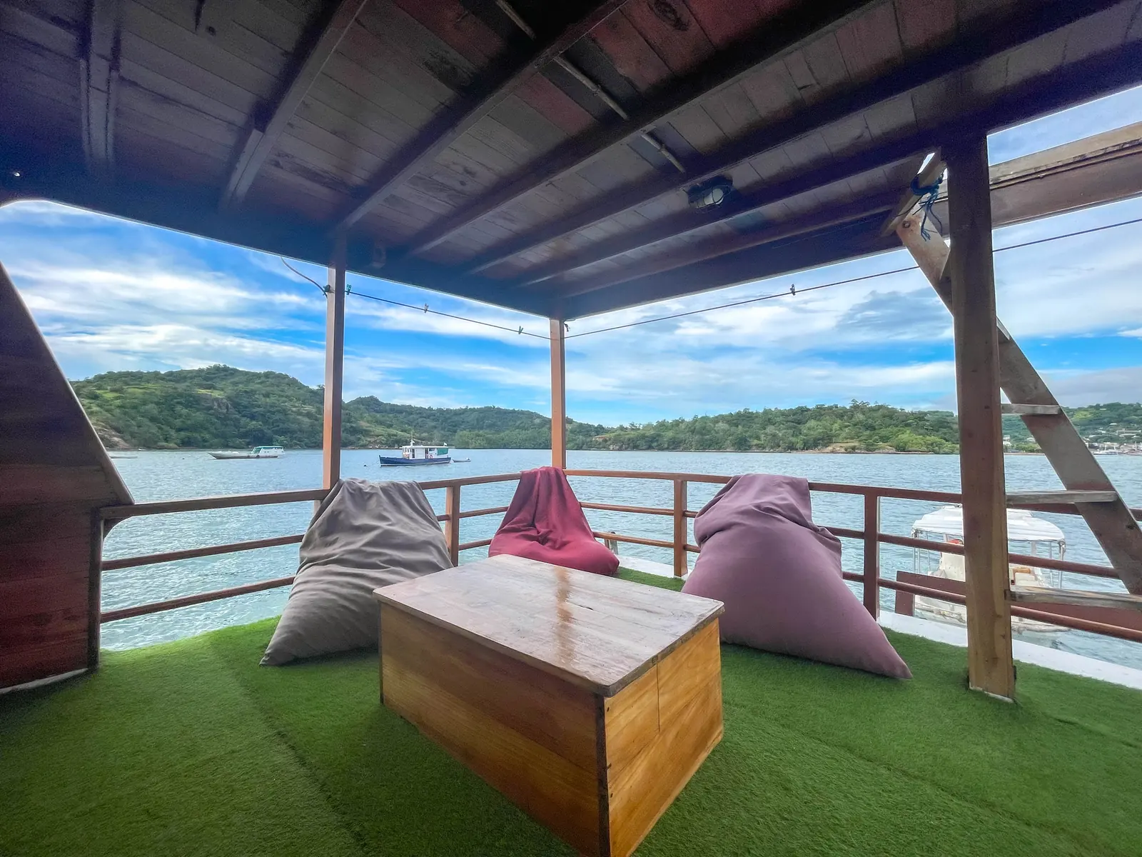 A lounge corner with artificial grass and bean bags facing the sea