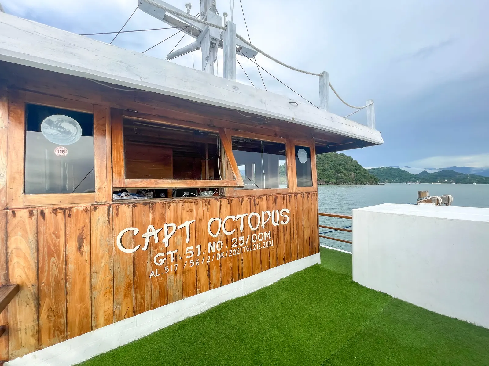Papan nama Capt Octopus di dinding kayu dek depan