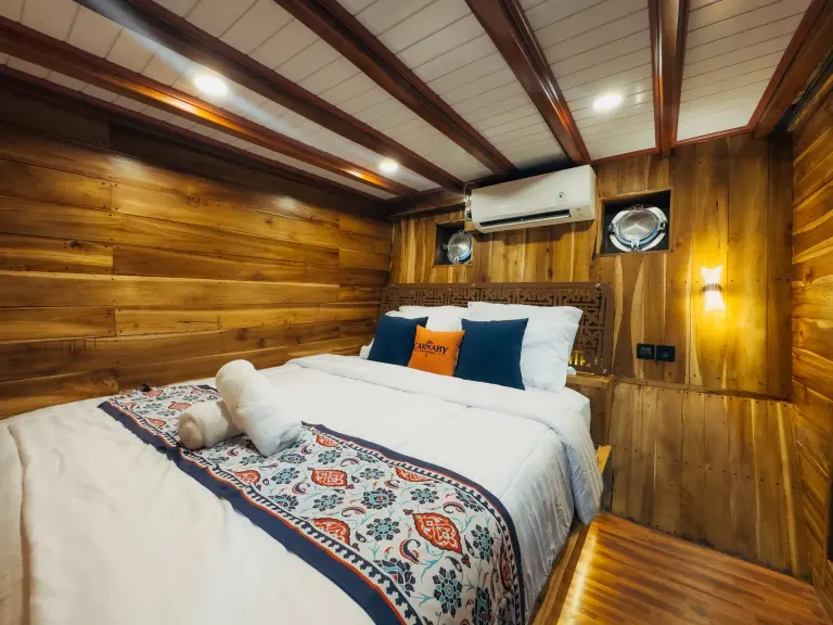 Carnaby II lower-deck Superior Cabin Sinjai, a double bed under the air conditioner and a porthole