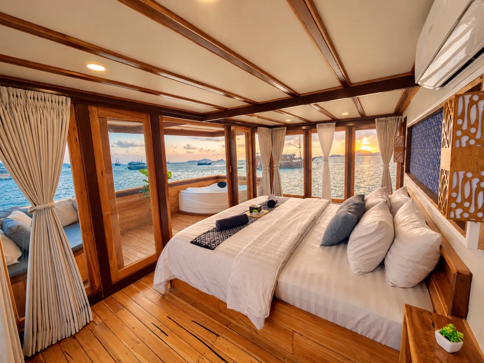 Hole in One master cabin on Delisa, king bed facing sea windows and a bathtub