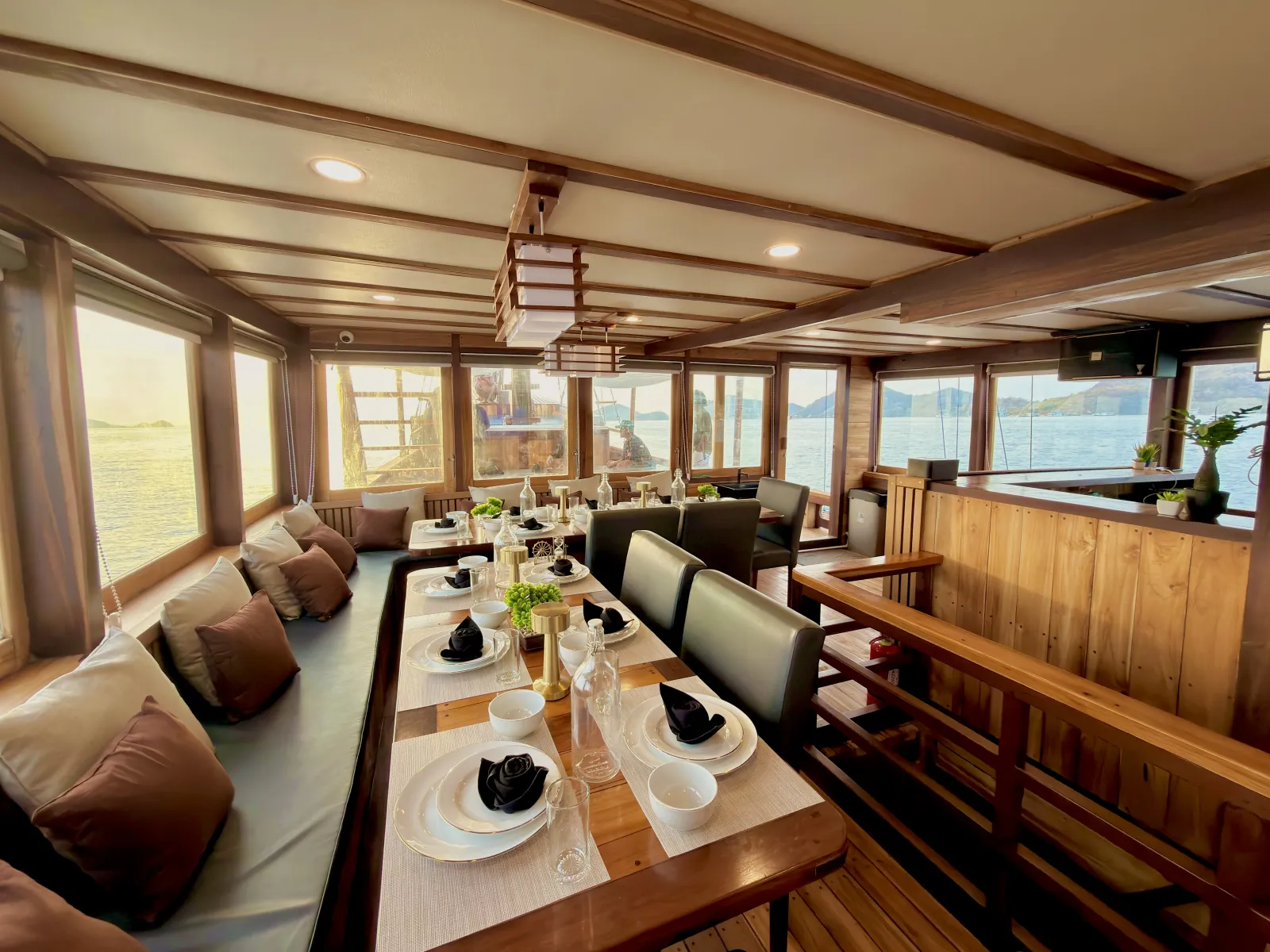 Indoor dining room on Delisa, long set tables beside the sea windows