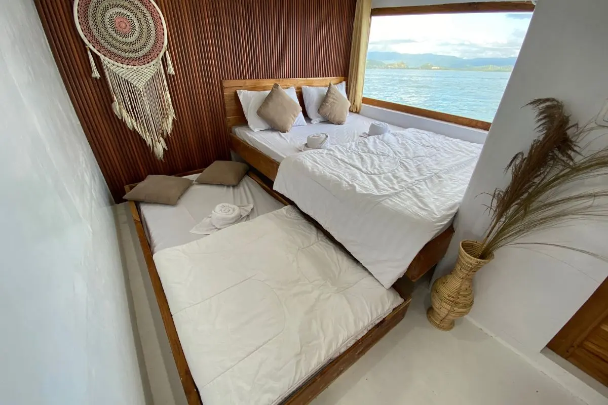Master Suite Cabin Gajah Putih di dek utama dengan dua kasur dan jendela laut