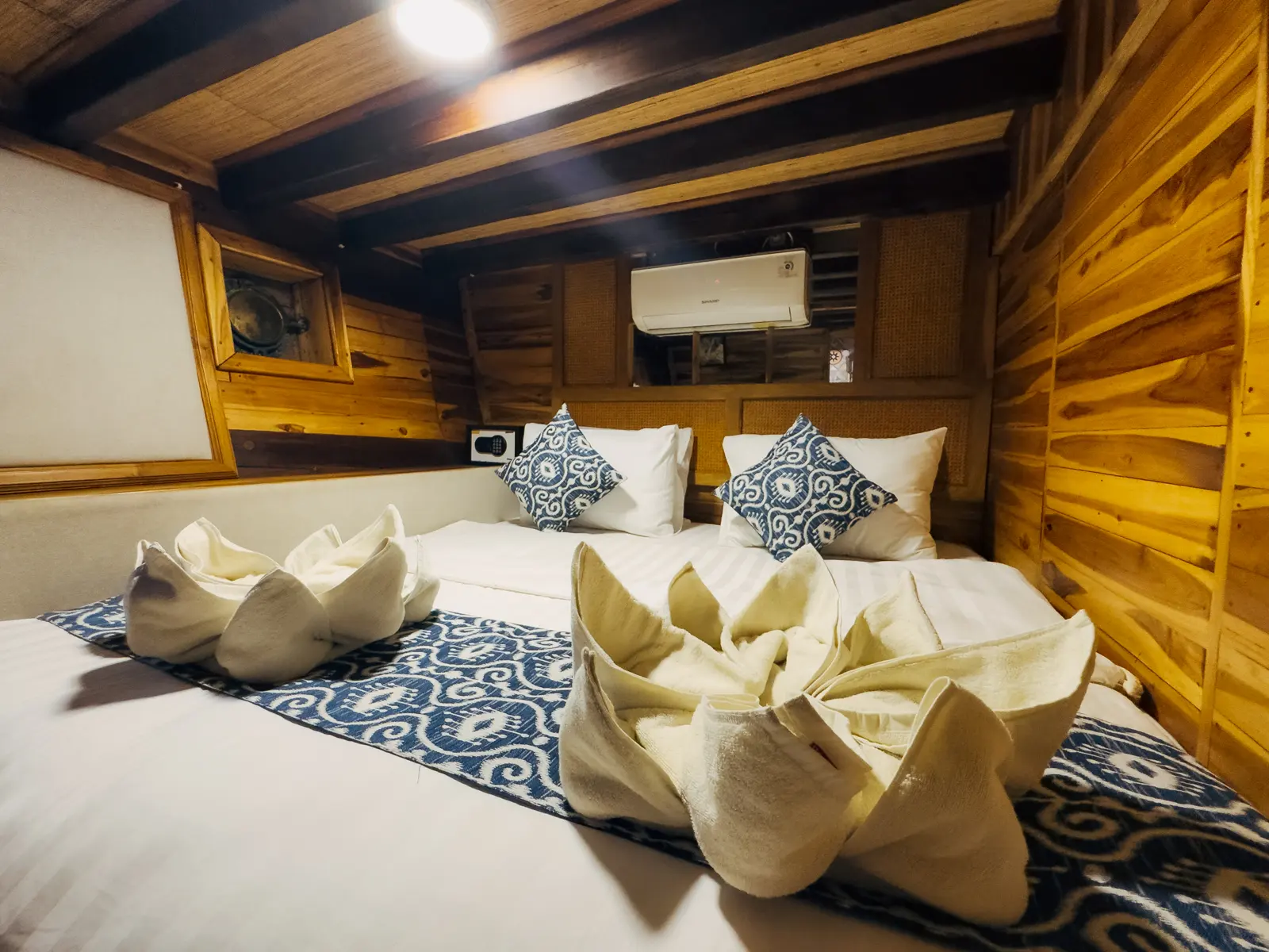 Deluxe Cabin on Gammara, lower deck, with wooden walls and blue patterned pillows