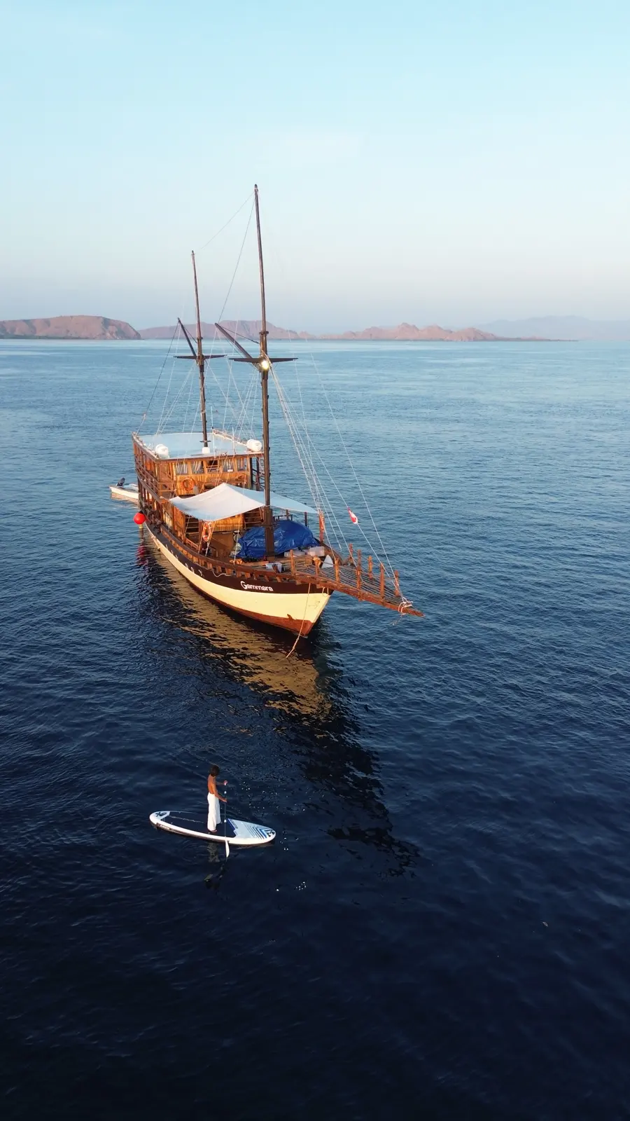 Gammara seen from astern with a guest on a paddle board nearby
