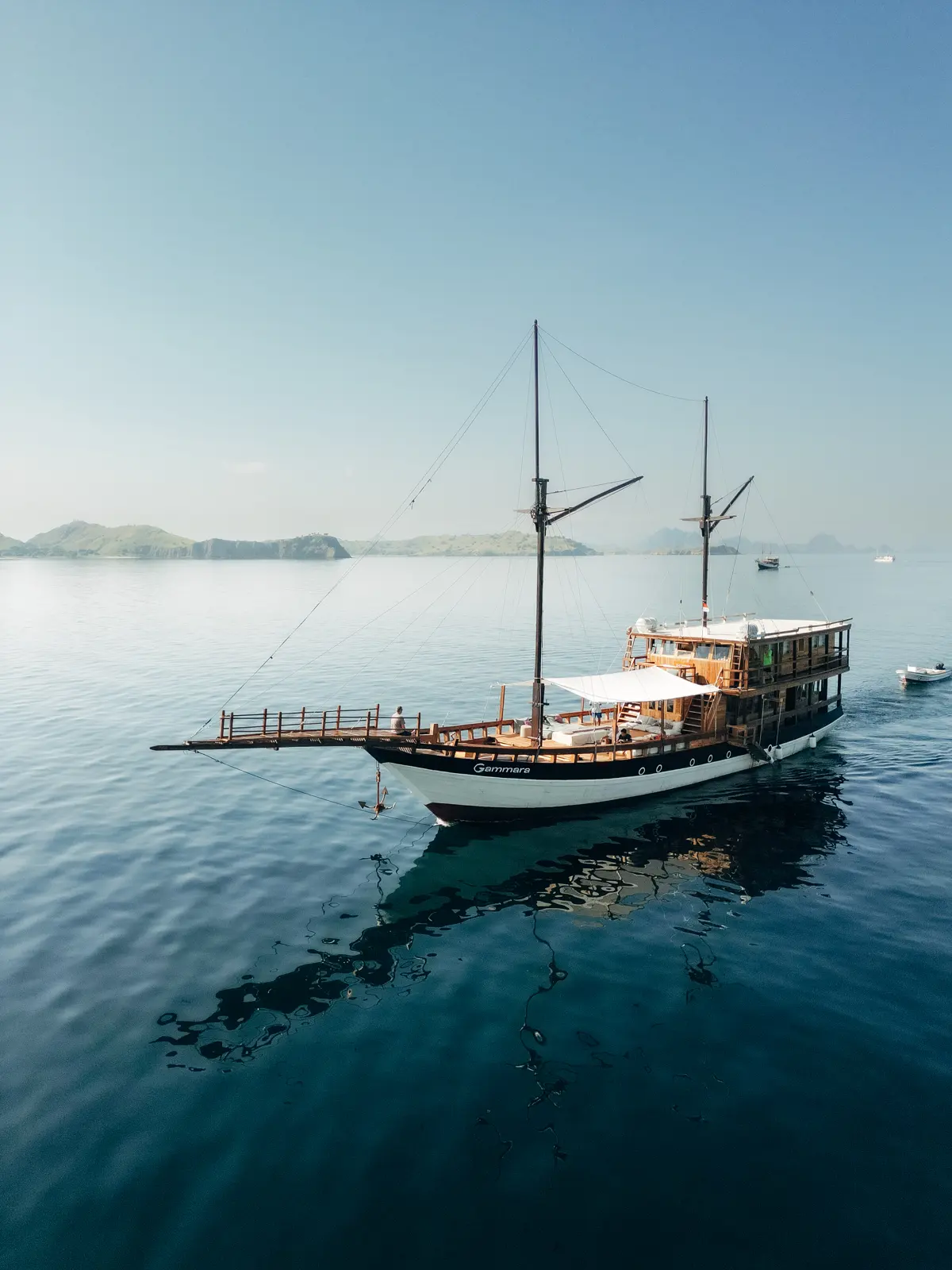 Gammara with furled sails on still water in the morning