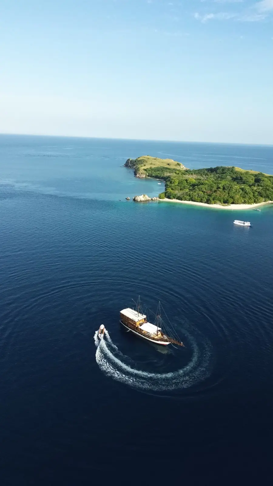 The Gammara speedboat curving past a green island, seen from the air