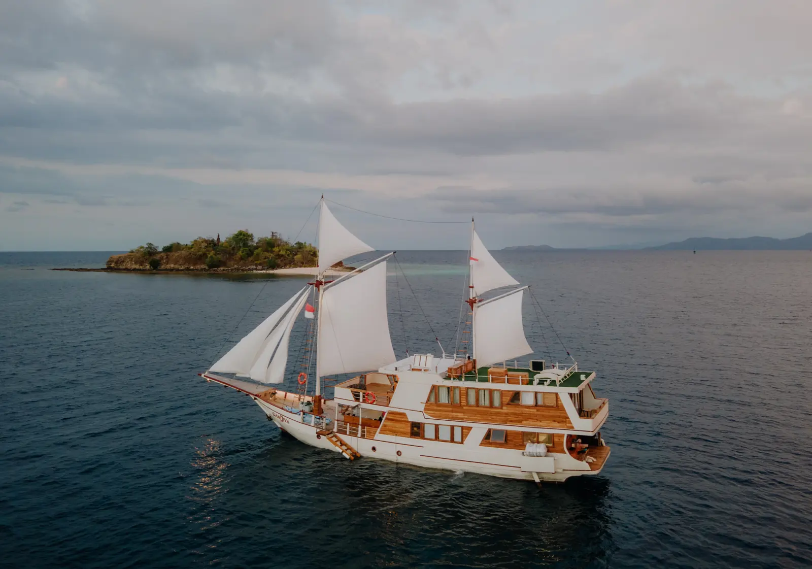 Phinisi Gandiva berlabuh di sebelah pulau karang berpohon di kawasan Komodo