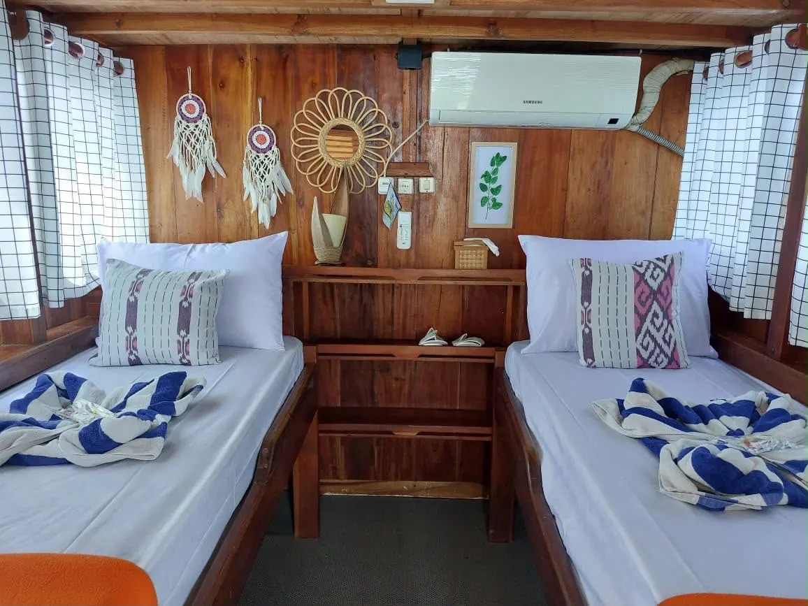 Deluxe Twin cabin on Ayla with two single beds and a wooden shelf between them