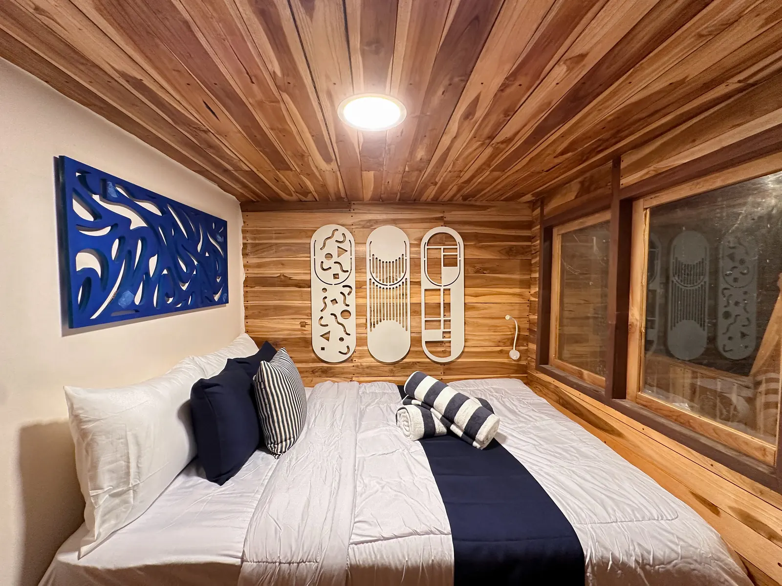 Azure cabin on Vhalé with a double bed, timber walls and white decorative panels