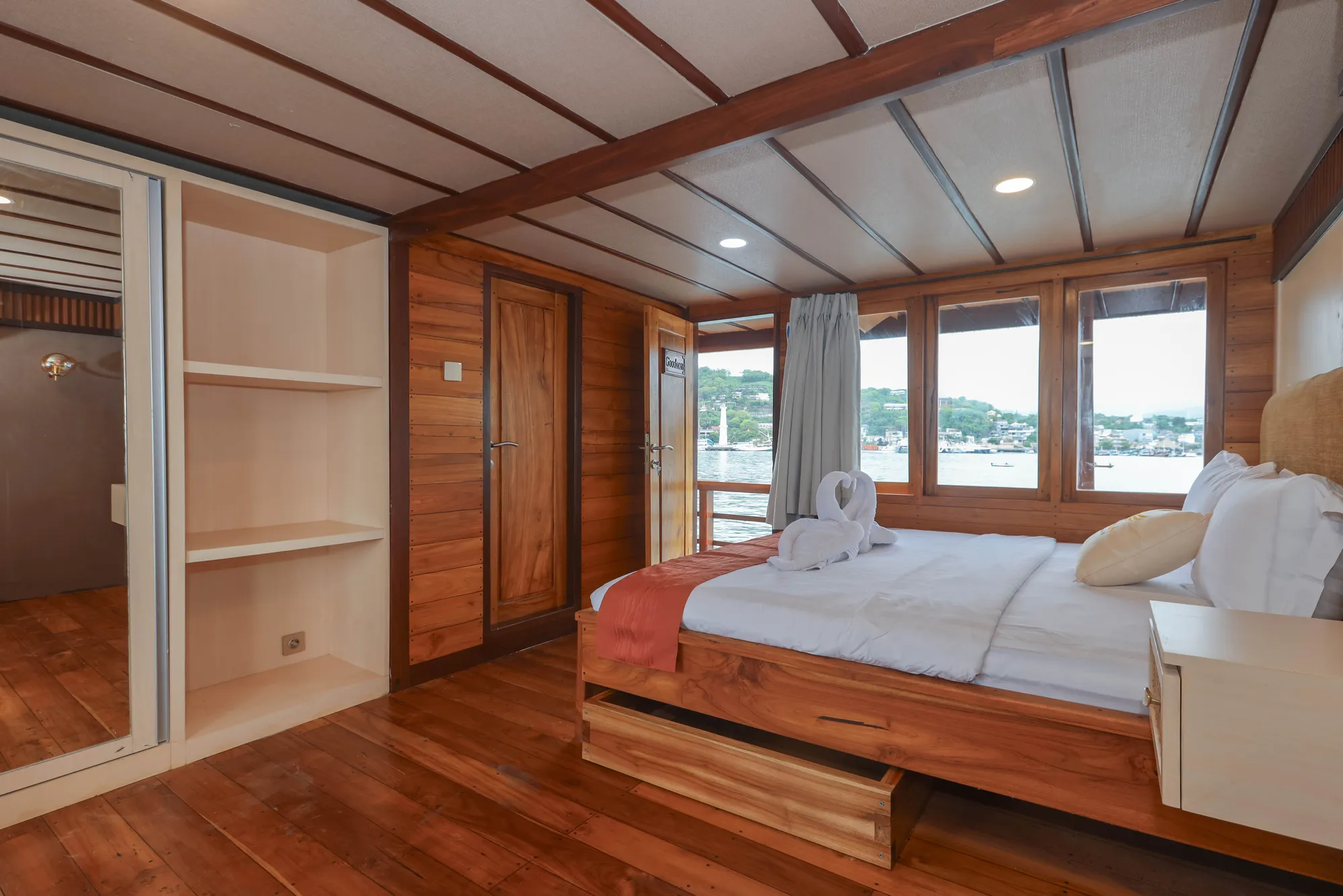 The Elrora Deluxe Cabin with a double bed and windows to the sea