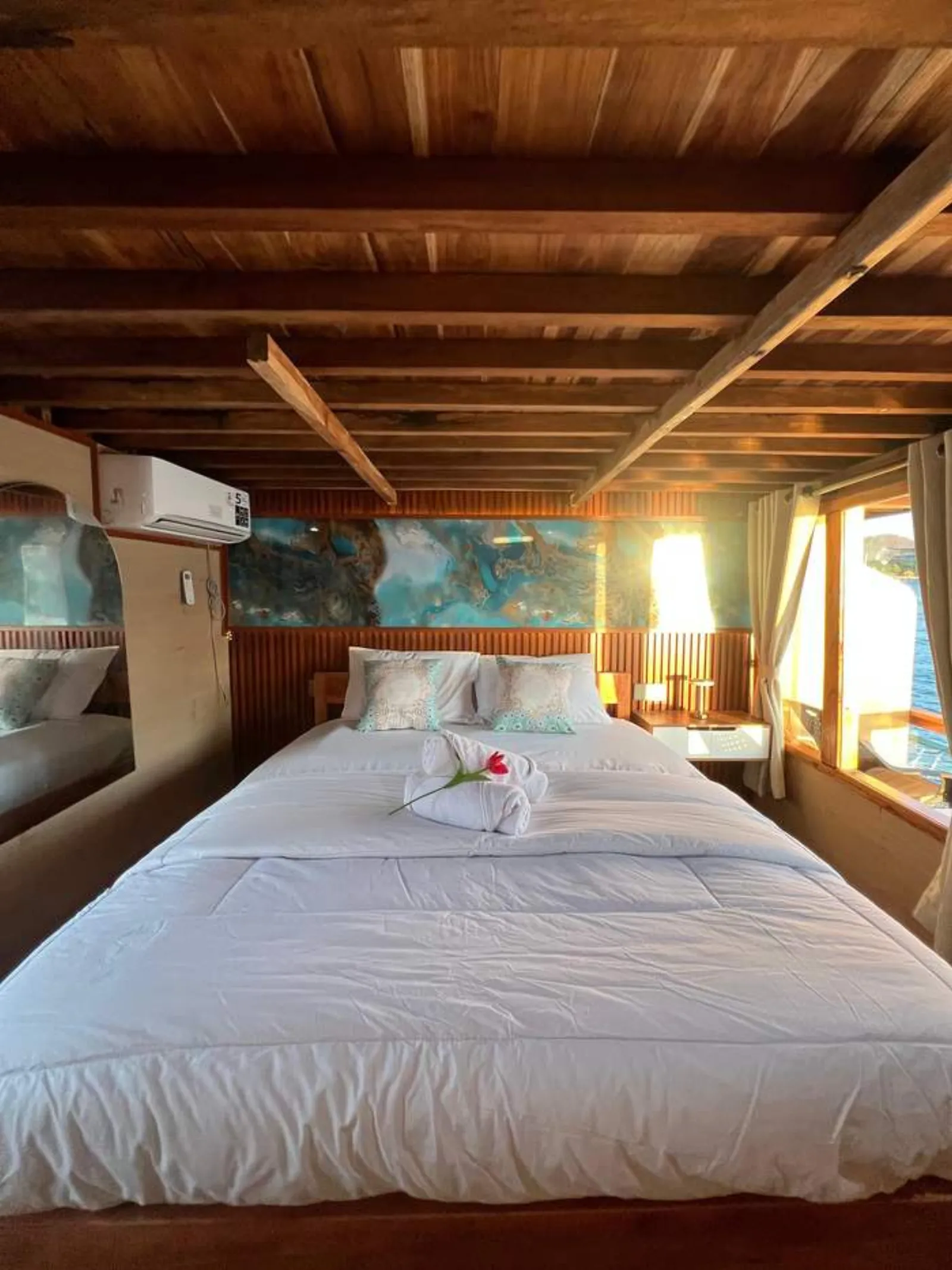 Ranjang queen berseprai putih di kabin Deluxe Ocean View GAN