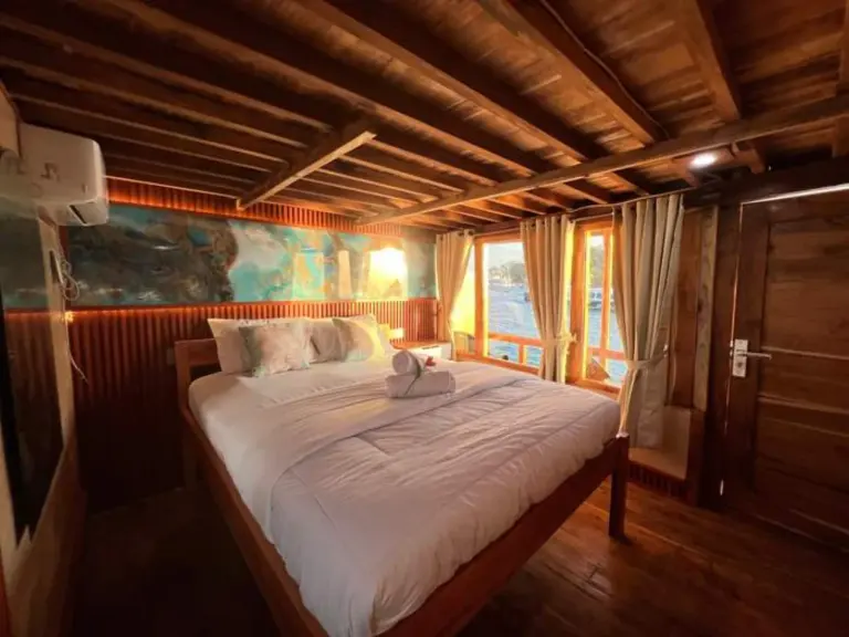 Kabin Deluxe Ocean View GAN dengan ranjang queen dan dinding kayu