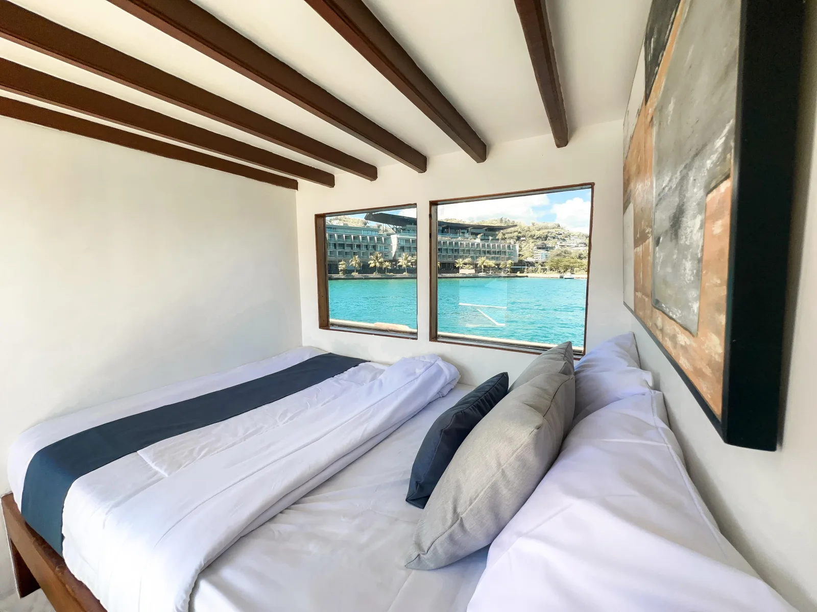 North Blue Master Room, a bed by windows facing the harbour
