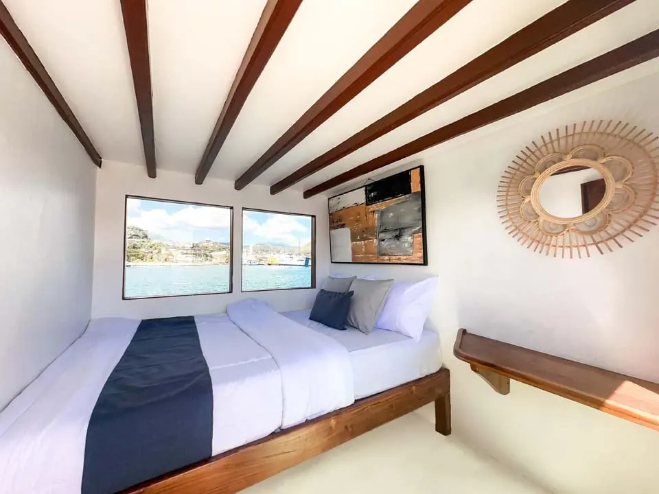 Corner of the North Blue Master Room with a wooden shelf and a rattan mirror