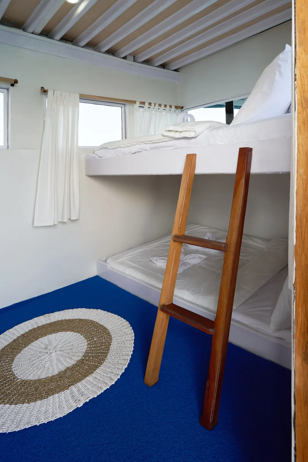 Shared Cabin 1 Ladyana, ranjang susun dengan tangga kayu dan karpet biru