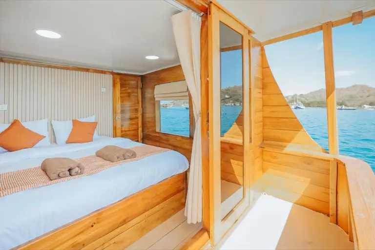 Master Cabin Balcony Segara, ranjang double dan pintu kaca ke balkon pribadi