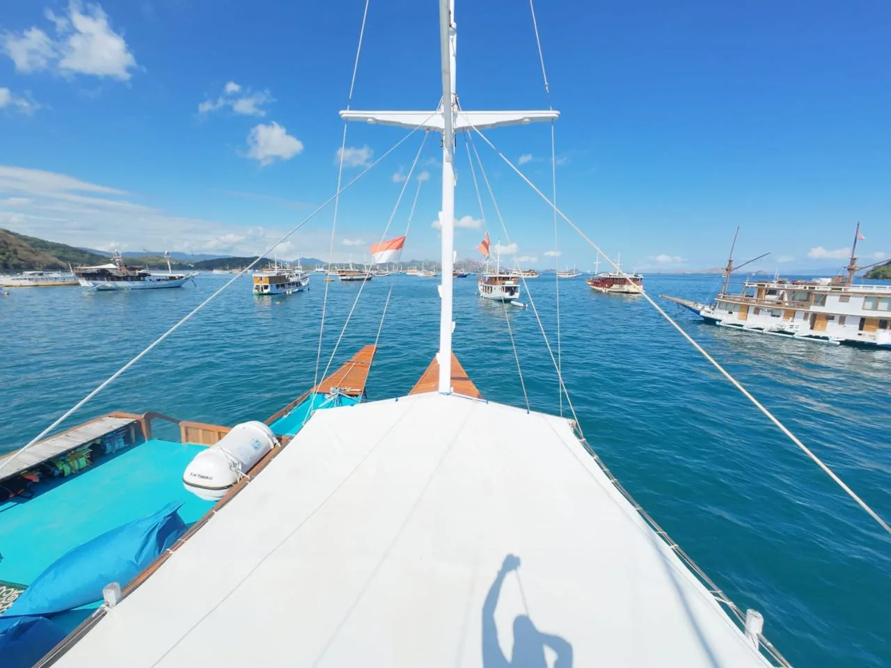 Dek depan KLM Arimbi dengan tiang layar dan laut biru di depan