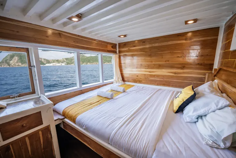 An NK Jaya Full Ocean cabin, a queen bed with wide sea windows