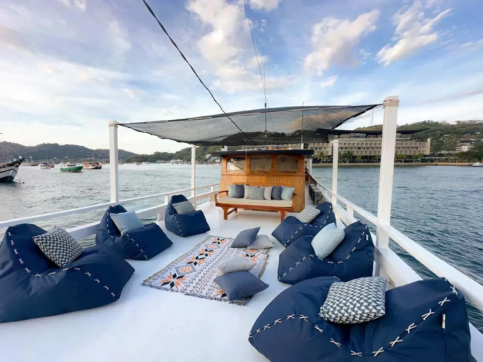 Dek atas North Blue dengan beanbag biru dan bangku di bawah atap jaring peneduh