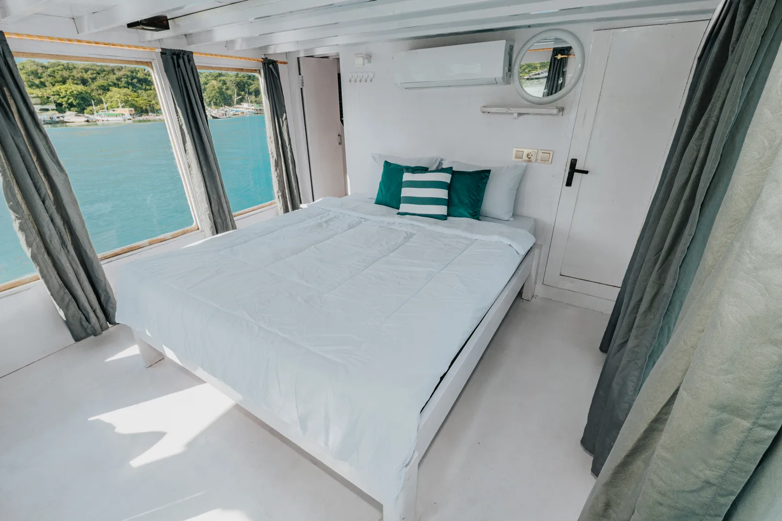 Master Cabin Sabira, queen bed dan jendela laut