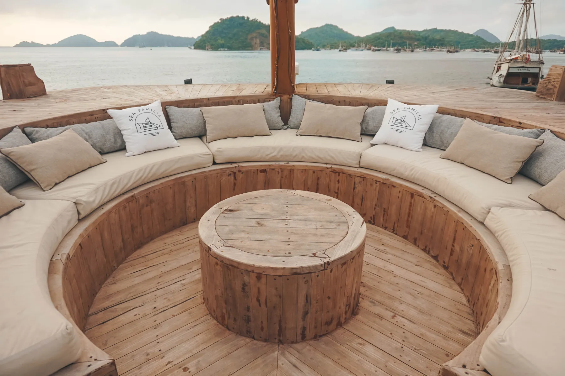 The sunken round sofa around a wooden table on the Sea Familia I front deck