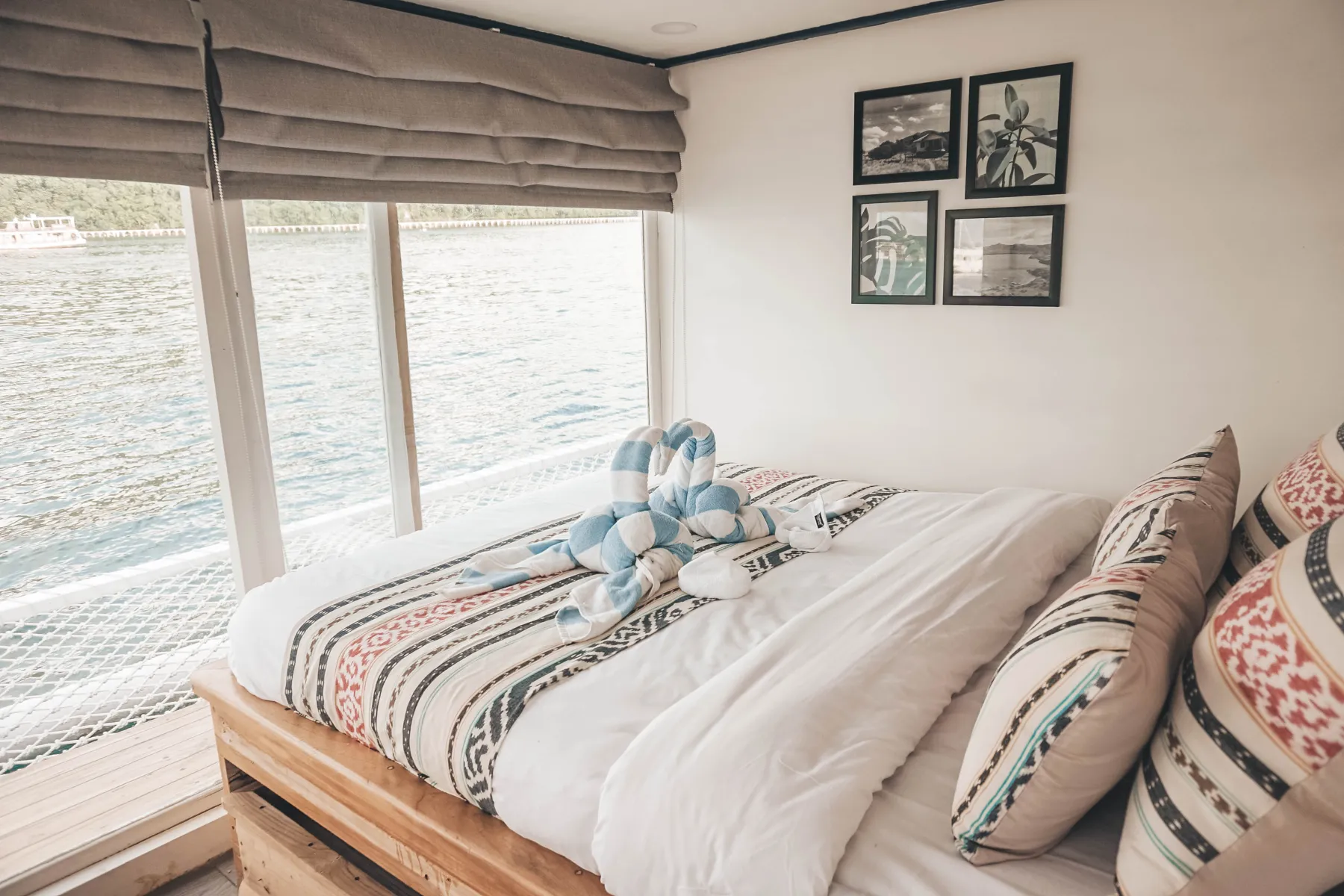 Sea Familia I Manta Cabin, a queen bed with framed prints and a wide sea window