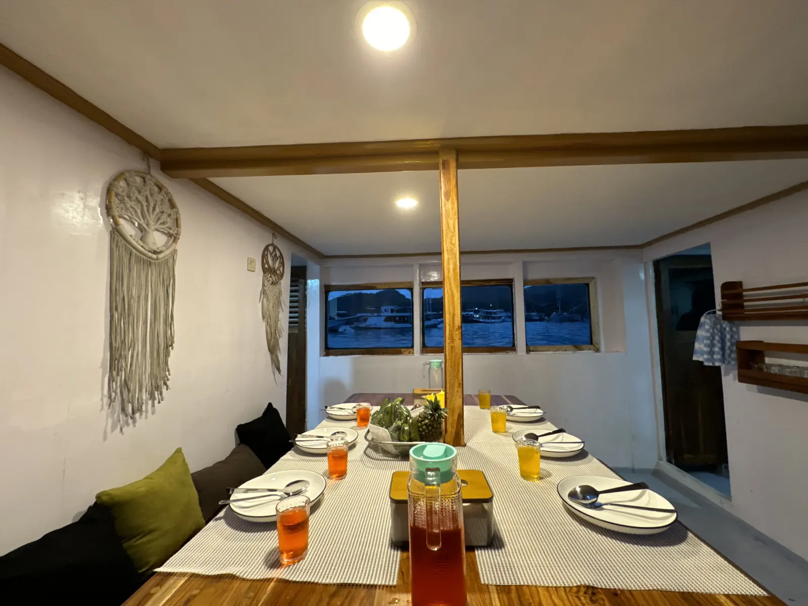 Umami indoor dining room, a long wooden table set with plates and drinks