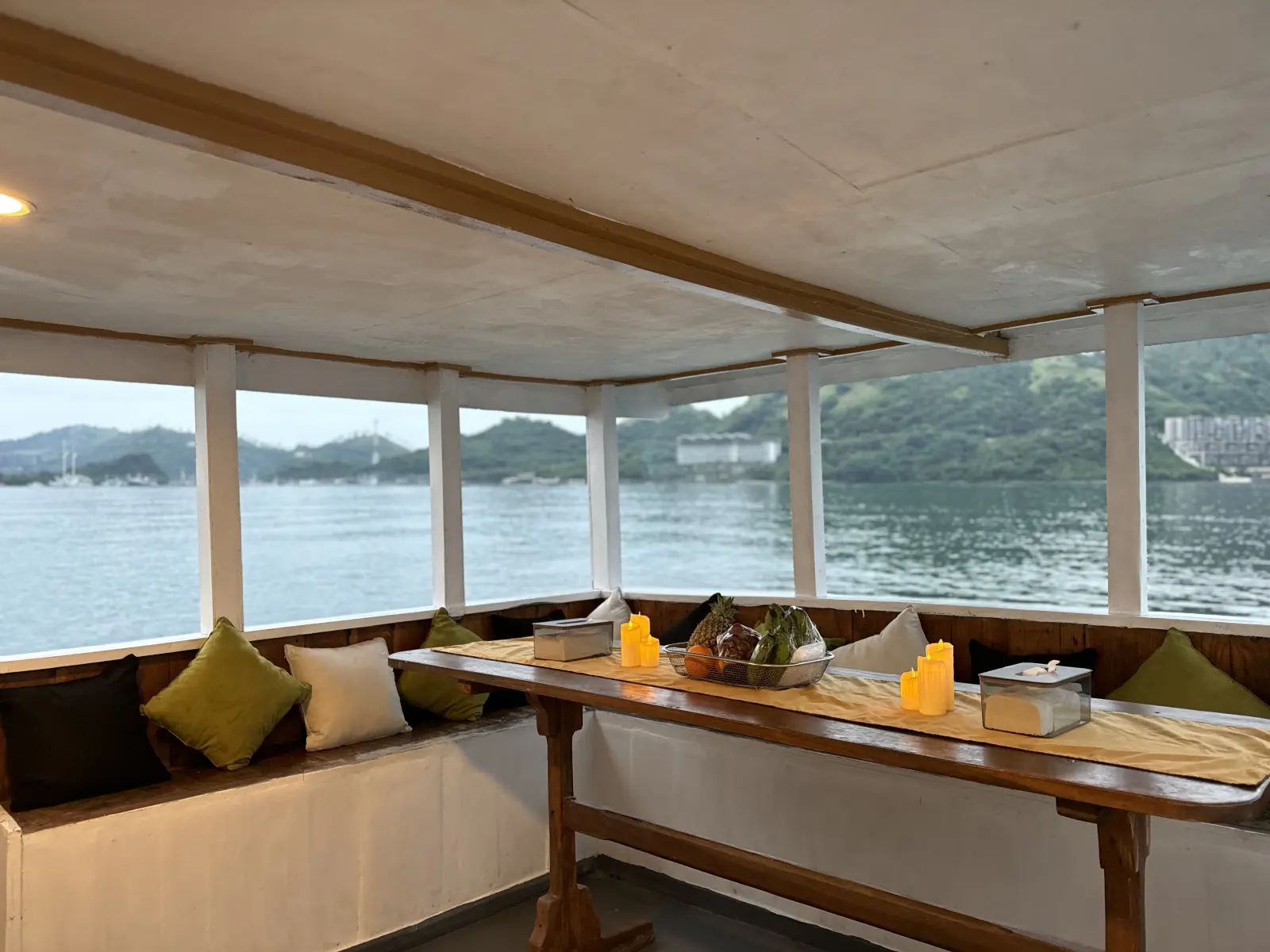 Umami front lounge, cushioned benches around a table with panoramic sea windows