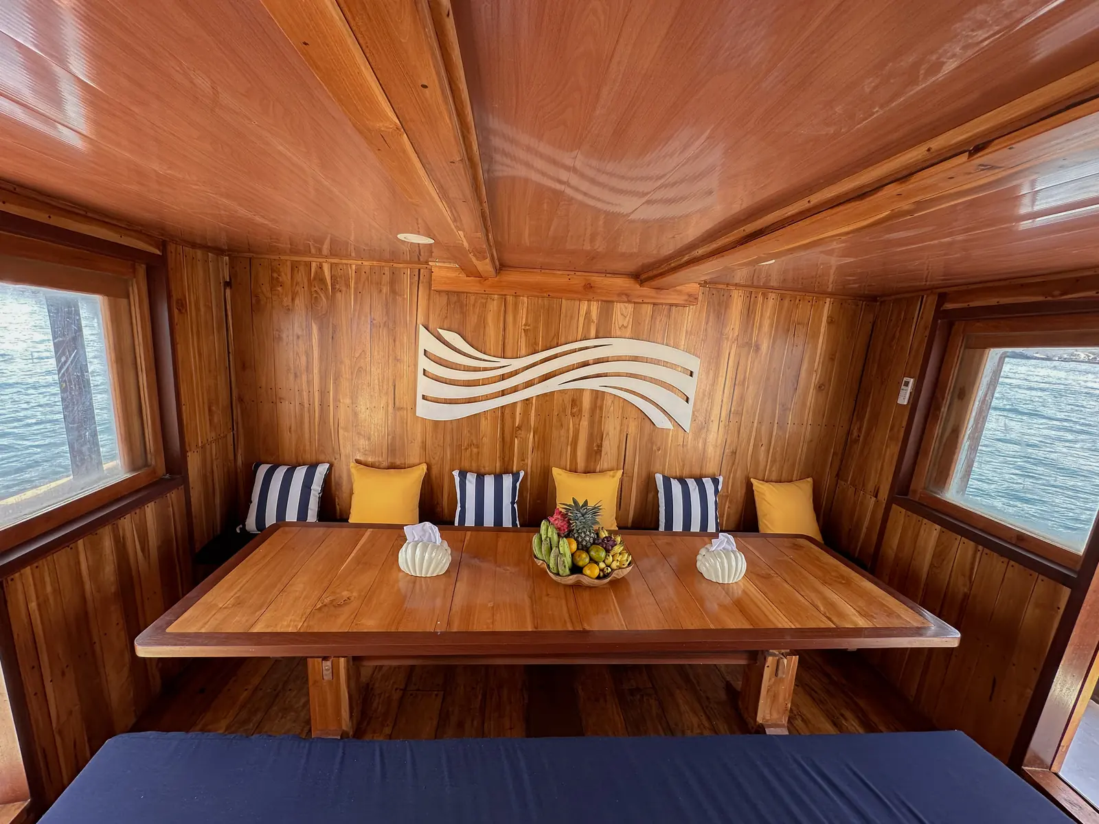 Ruang makan dalam Vhalé berdinding kayu dengan meja panjang dan bangku berbantal