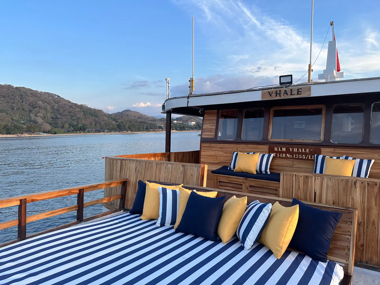 Bow sundeck on Vhalé with blue and white striped mattresses in front of the wheelhouse